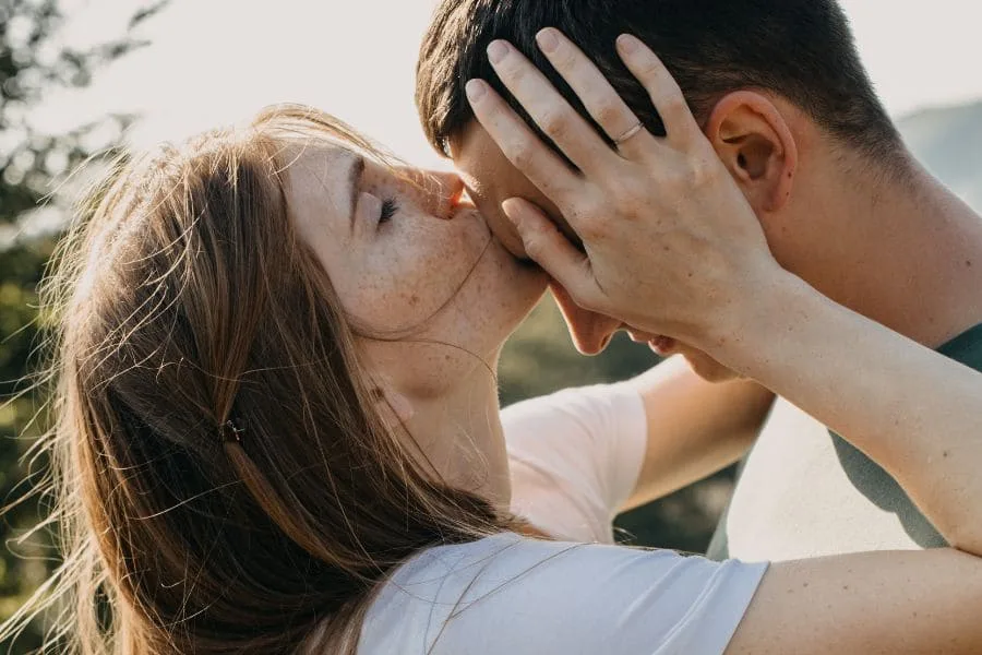 woman kissing her girlfriend forehead