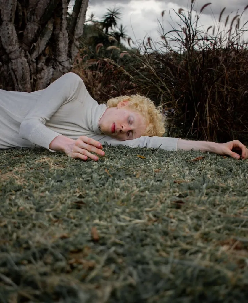 a young albino man sleeping on the floor