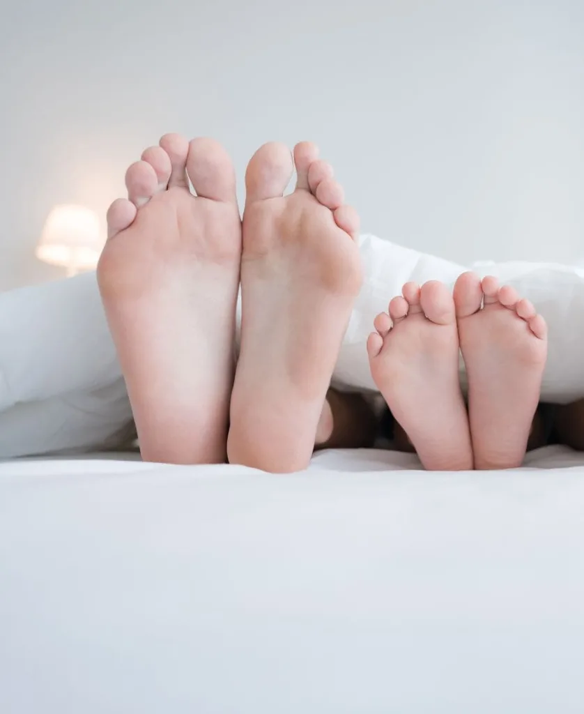 Feet of an adult next to feet of a child