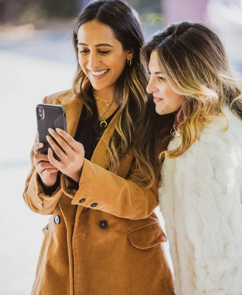 Two women looking a mobile phone